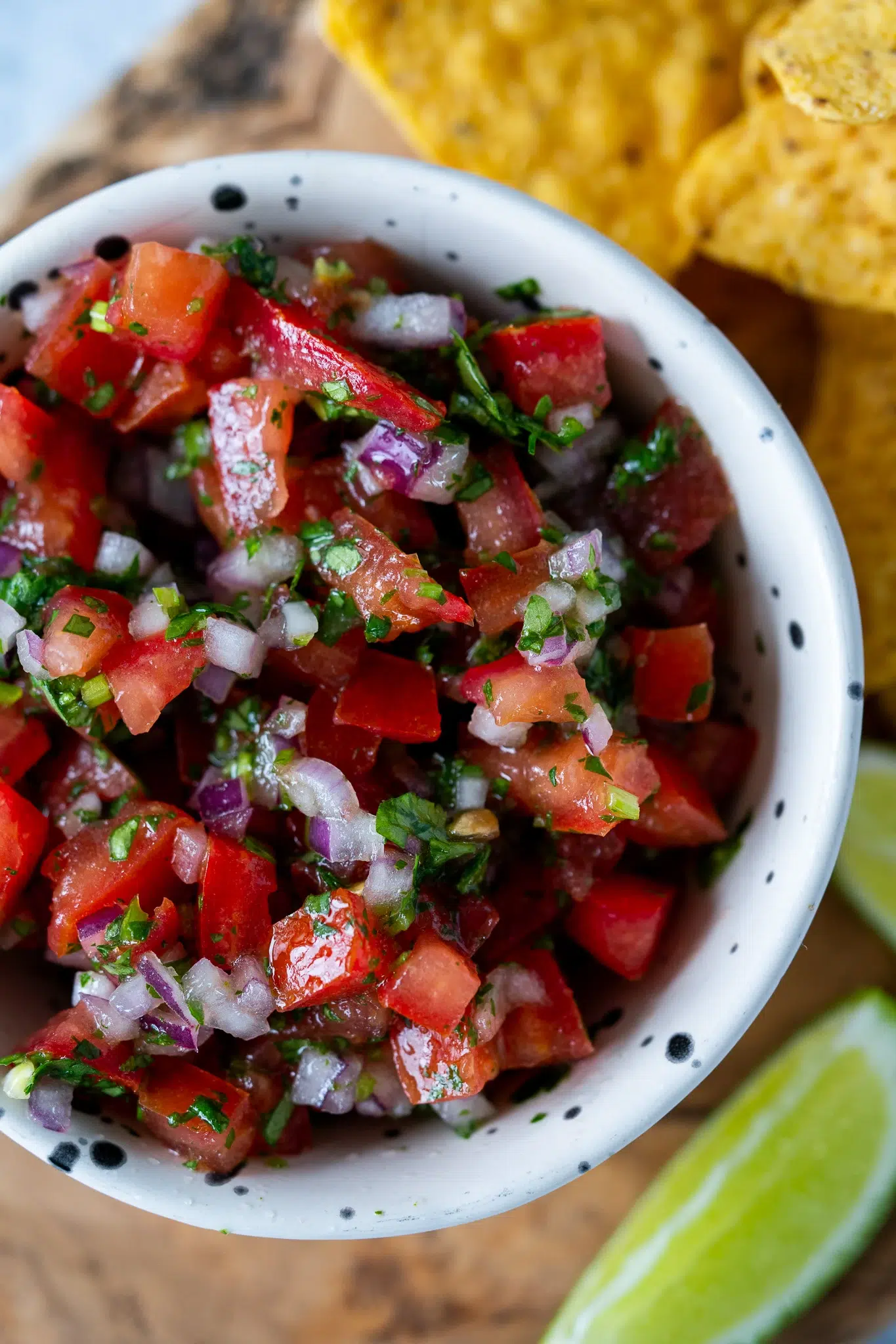 Close-up of classic pico de gallo in a bowl, made with ripe tomatoes, red onion, chili, coriander, lime, and salt