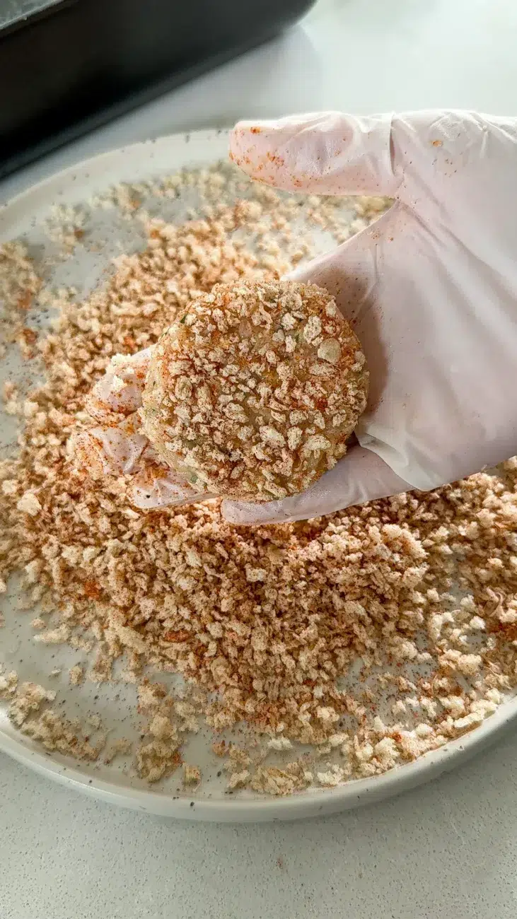 formed chicken rissole in hand glove on