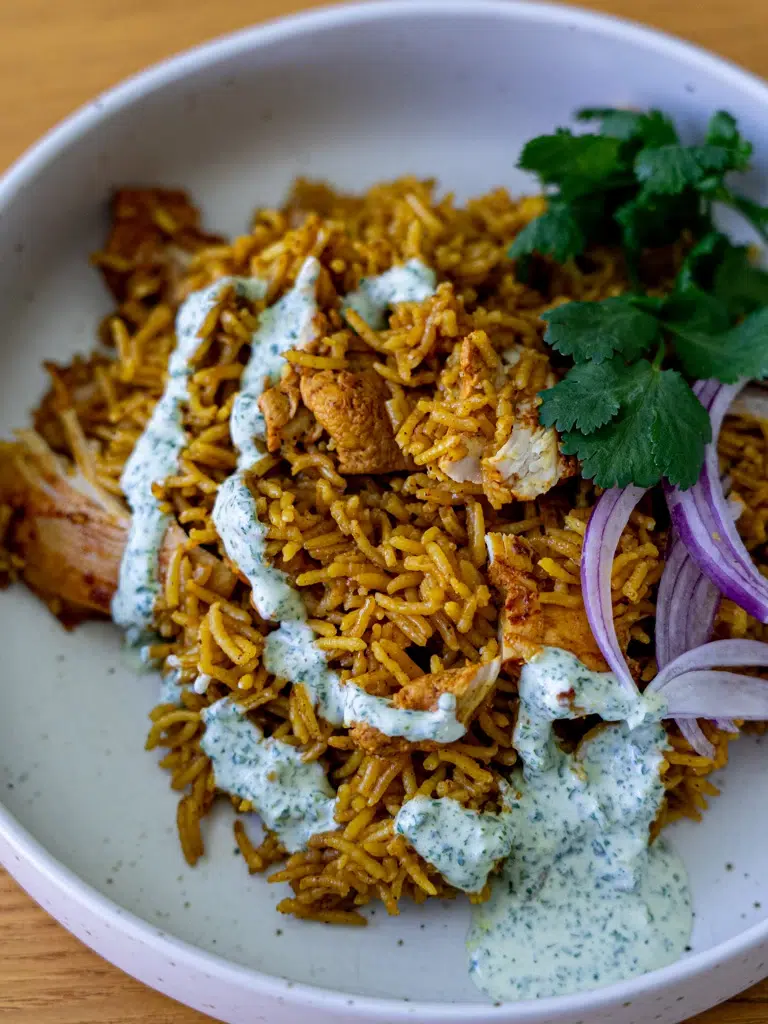 One-pan Tandoori Chicken and Rice – spiced chicken over fragrant rice, plated with a refreshing mint yogurt drizzle