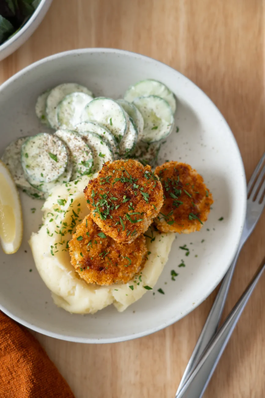 plated chicken rissoles with mashed potatoes and cucumbers