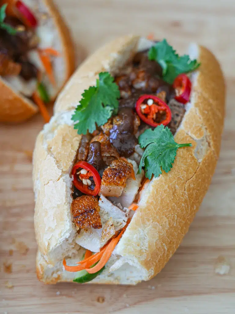 Close-up of Pork Belly Banh Mi showcasing the filling and sauce.